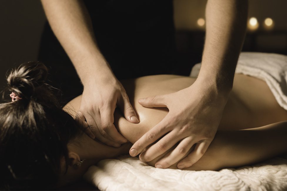Spa guest receiving a shoulder massage from a therapist