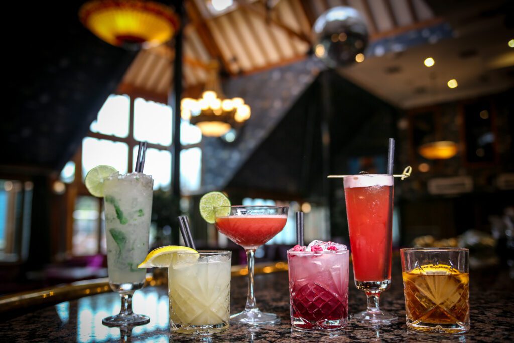 A selection of Cocktail drinks alined on the bar.