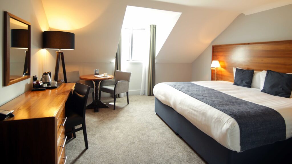 Superior Hotel bedroom with bed, TV, desk and chair at Old Thorns Hotel & Resort