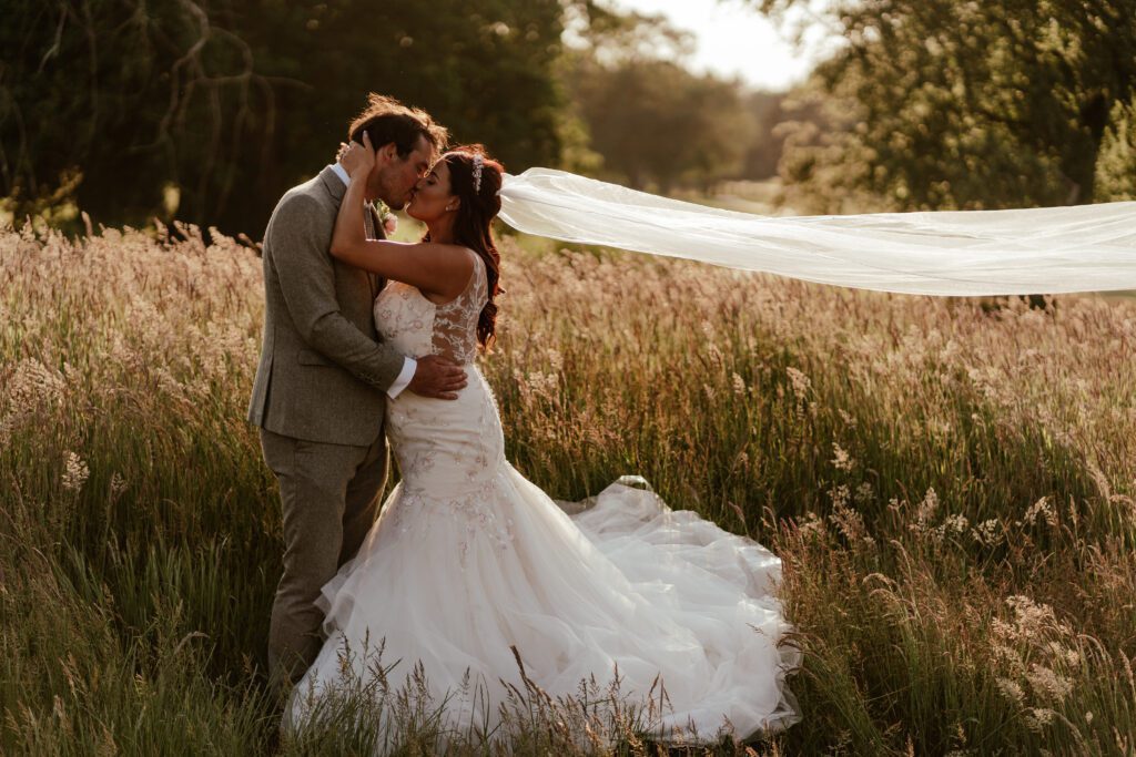 Photo of Bride & Groom in long grass located at Old Thorns Golf Course.