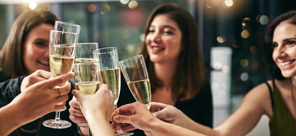 Group of young ladies toasting during a dinner party at a restaurant