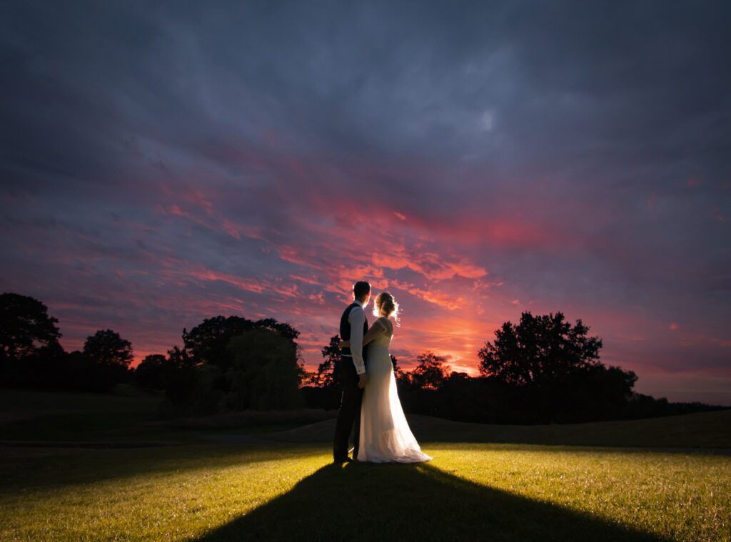 Photograph of Bride and Groom enjoying the view of a sunset on Old Thorns Golf Course