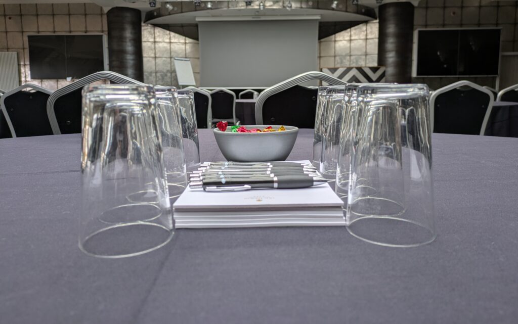 Conference pads pens sweets and glasses in the Gatsby Ballroom