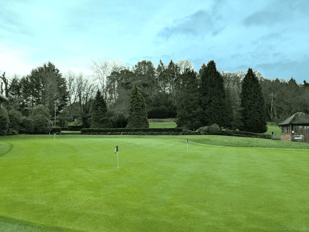 Golf practice area with putting greens and flags at Old Thorns resort.