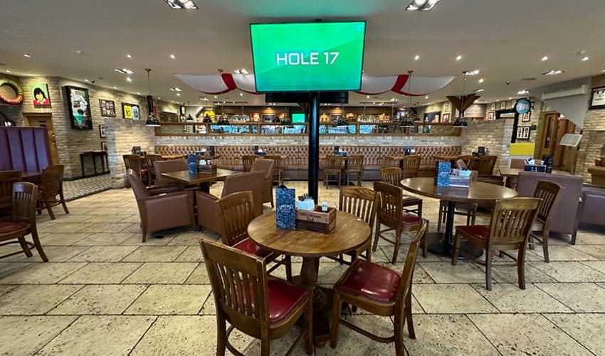 Golf lounge with seating area, large screen, and bar at Old Thorns Golf & Country Estate.