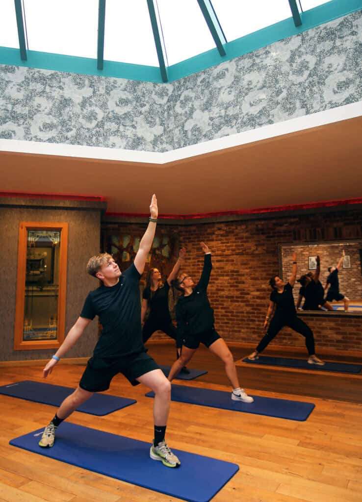 Group of people practicing yoga in a studio at Old Thorns Golf & Spa.