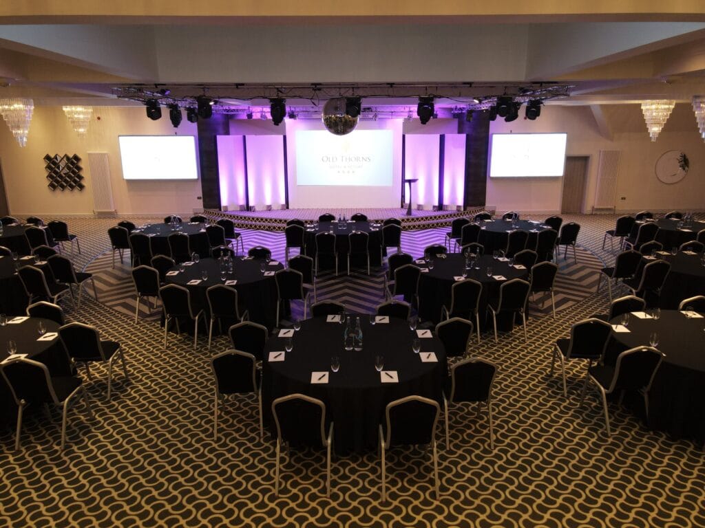 Modern conference room setup at Old Thorns with stage and seating.