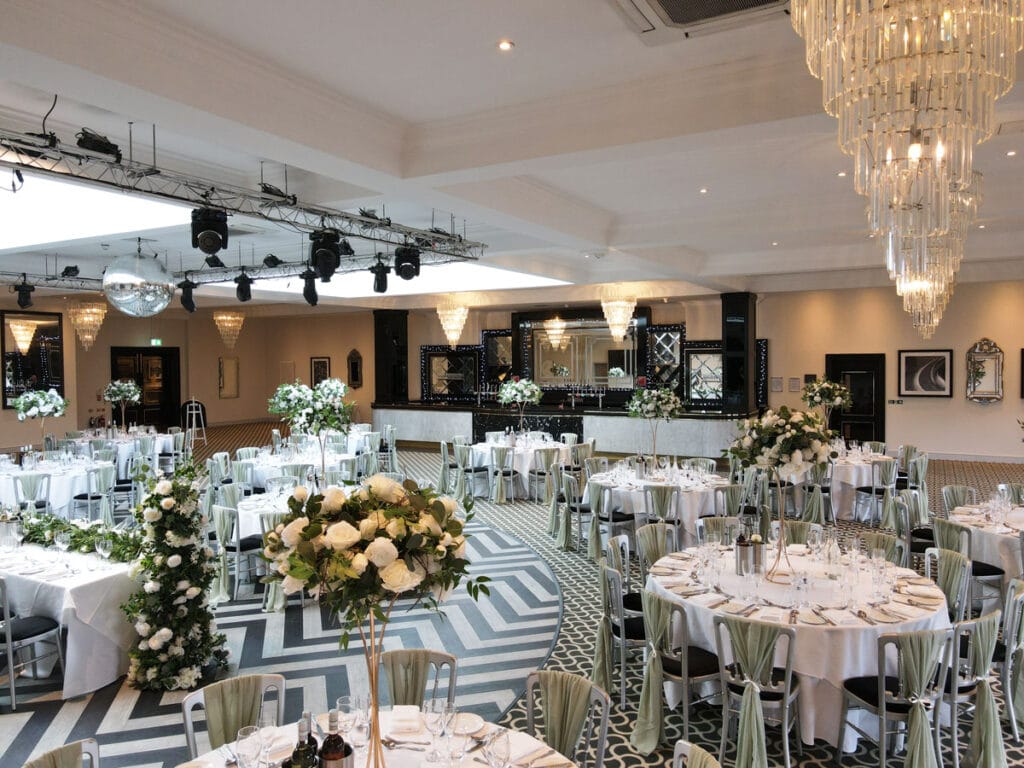 Stylish wedding reception setup with floral centrepieces and elegant table arrangements.