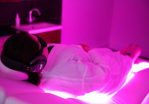 Spa guest relaxing on the Wellness Bed with eye mask and headphones on
